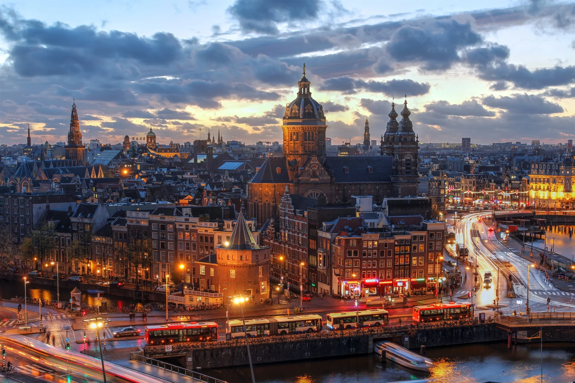 Amsterdam at dusk, the Sint Nicolaaskerk above the lights along the water