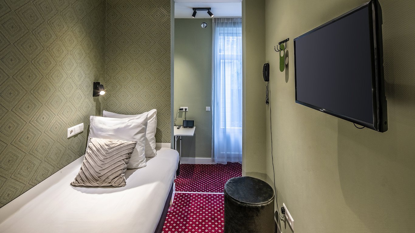 The room down its length, the flat-screen TV on the wall and the window at the far end