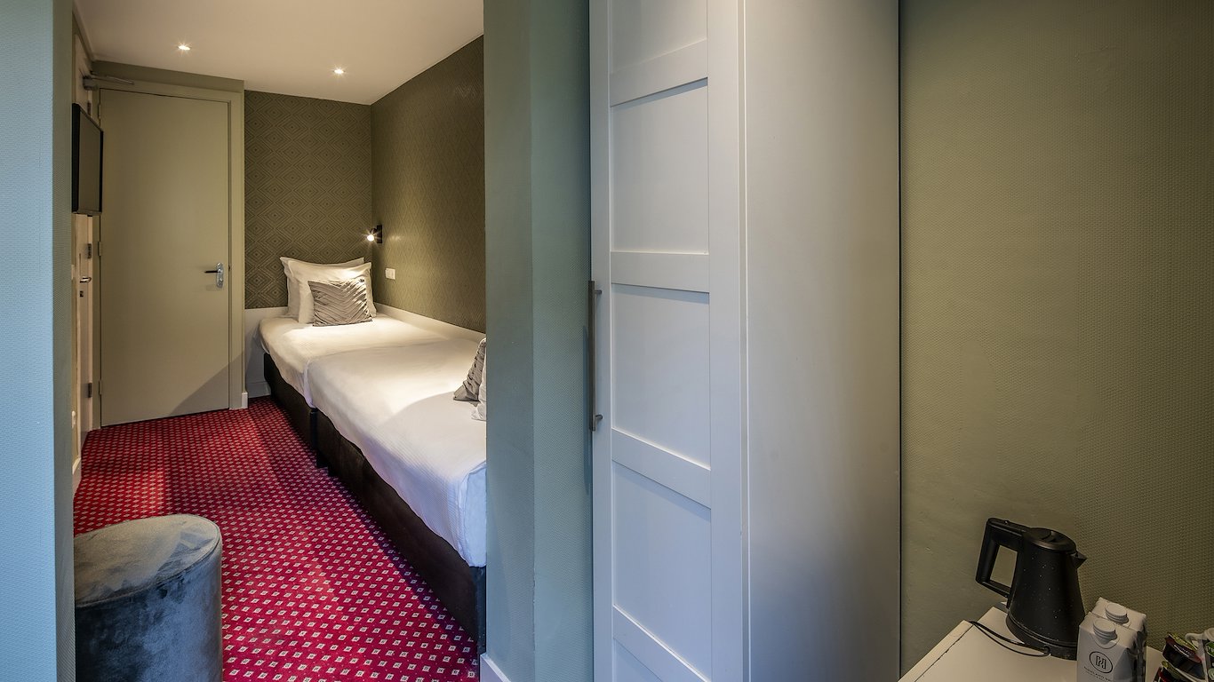 The beds seen past the bathroom door, with the kettle on the counter in the foreground